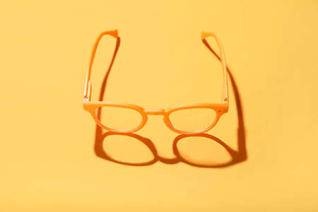 Plastic eyeglasses on orange backgroundの写真素材