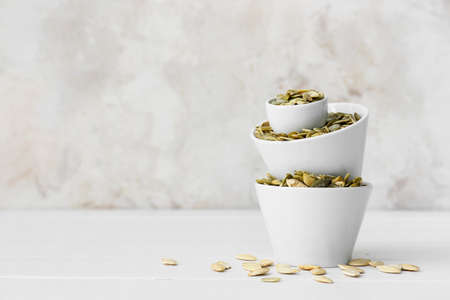 Bowls with pumpkin seeds on tableの写真素材