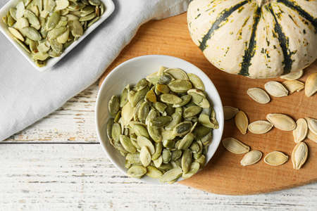 Bowls of pumpkin seeds on white wooden backgroundの写真素材