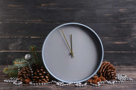 Stylish New Year clock with Christmas decor on dark wooden backgroundの写真素材