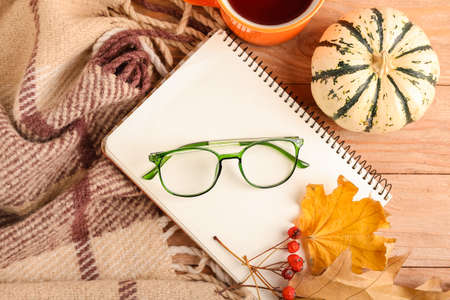 Composition with eyeglasses, notebook and pumpkin on wooden backgroundの写真素材