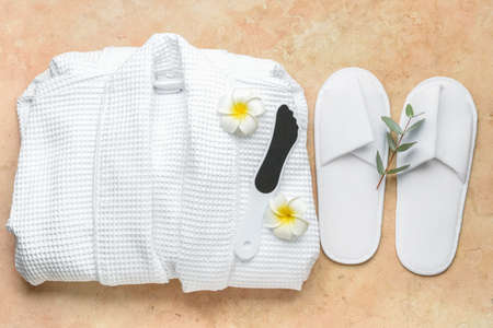 Bathrobe, foot file for massage and slippers on color backgroundの写真素材
