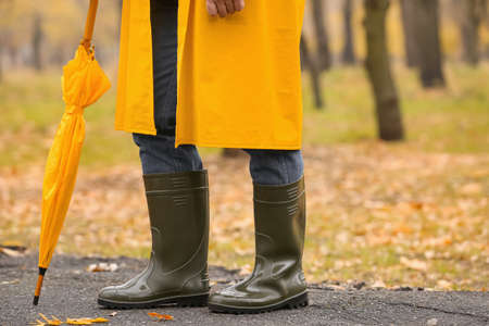 Man wearing gumboots in park on autumn day