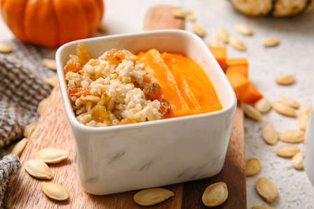 Bowl of tasty oatmeal with pumpkin on white backgroundの写真素材