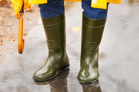 Man wearing gumboots in park on autumn day, closeupの写真素材