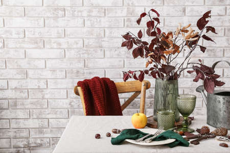 Beautiful table setting and autumn decor on table in room