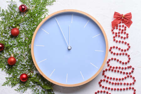 Stylish New Year clock with Christmas decor on white background