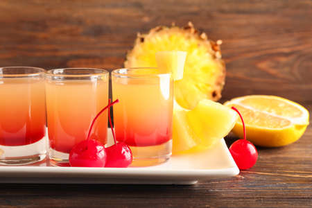 Plate with tasty Pineapple Upside Down Cake Shots on wooden background, closeupの写真素材