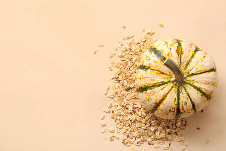 Oatmeal flakes and pumpkin on beige backgroundの写真素材