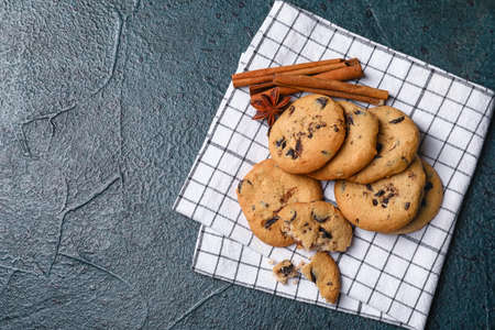 Tasty cookies with chocolate chips on dark background