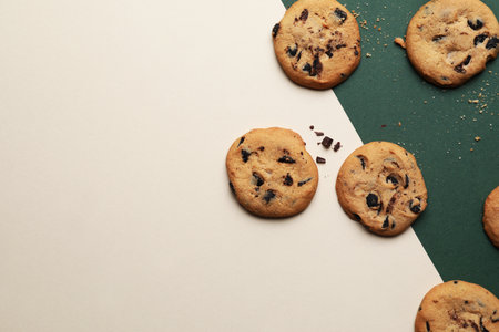 Delicious homemade cookies with chocolate chips on color backgroundの写真素材
