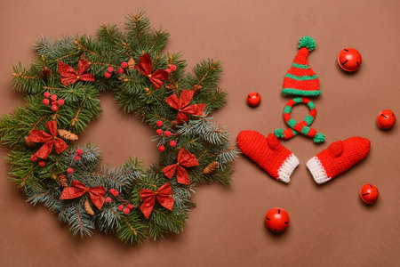 Beautiful Christmas wreath made of fir branches and decor on brown background