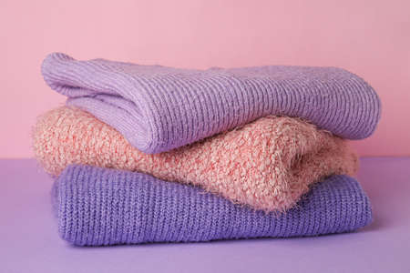 Stack of soft warm sweaters on color backgroundの写真素材