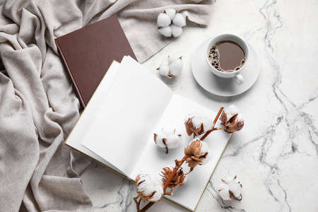 Cup of coffee, opened book with blank pages and beautiful cotton flowers on light backgroundの写真素材
