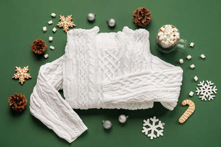 Warm sweater and winter decor on green backgroundの写真素材