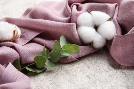 Fabric, cotton flowers and eucalyptus branch on grunge tableの写真素材