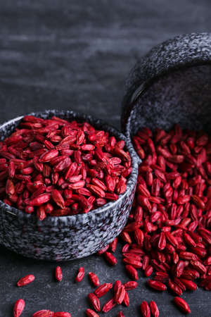 Bowl with dried barberries on dark background