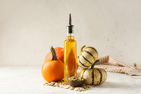 Bottle with pumpkin seed oil on light backgroundの写真素材