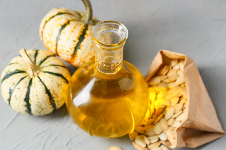 Jug with pumpkin seed oil on gray backgroundの写真素材