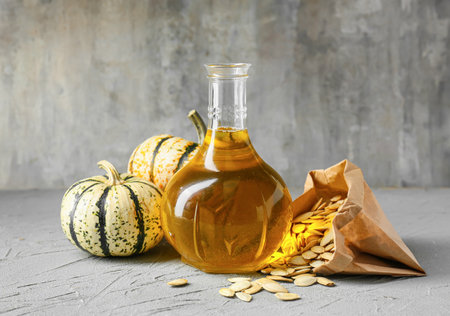 Jug with pumpkin seed oil on gray backgroundの写真素材