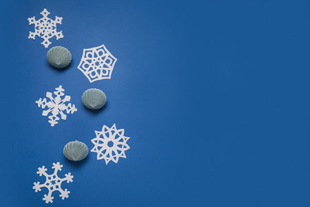 Beautiful paper snowflakes and Christmas balls on blue backgroundの写真素材