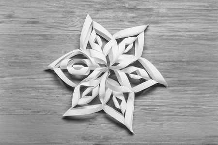 Beautiful paper snowflake on gray wooden backgroundの写真素材