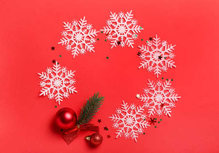 Frame made of snowflakes and Christmas balls on red backgroundの写真素材
