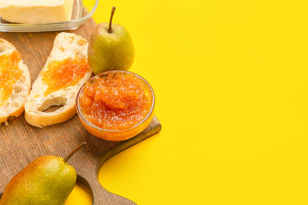 Bread with tasty pear jam and butter on yellow background, closeupの写真素材
