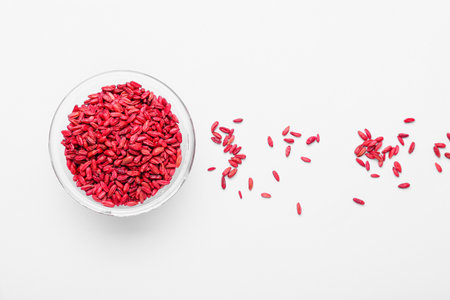 Glass bowl with dried barberry on white background