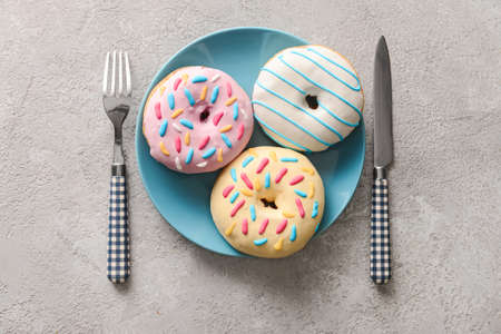 Plate with delicious donuts on gray backgroundの写真素材