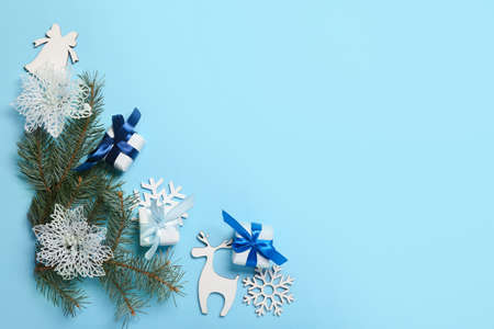 Christmas composition with gift boxes, decor and fir branches on blue background