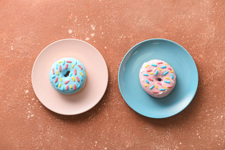 Plates with delicious donuts on color backgroundの写真素材