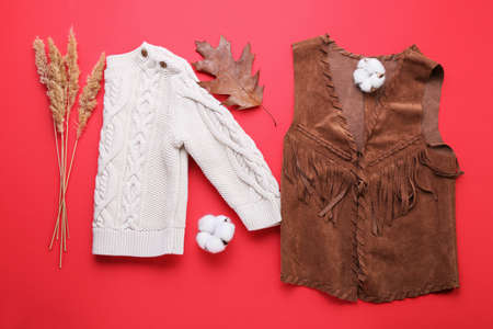Baby clothes and natural forest decor on red backgroundの写真素材