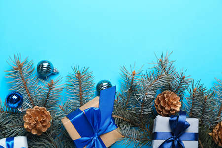 Christmas composition with gift boxes, balls and fir branches on blue backgroundの写真素材