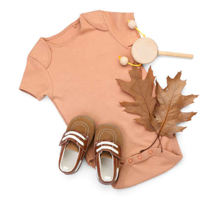 Baby bodysuit, shoes, toy and autumn leaves on white backgroundの写真素材