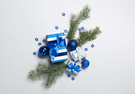 Christmas composition with gift boxes, balls and fir branches on light backgroundの写真素材