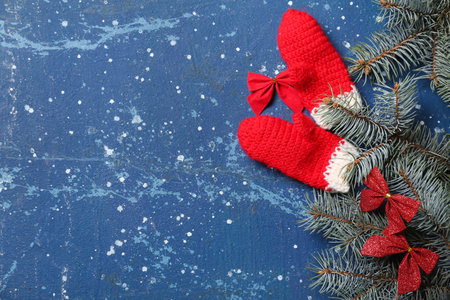 Christmas composition with gloves and fir branches on blue background, closeupの写真素材