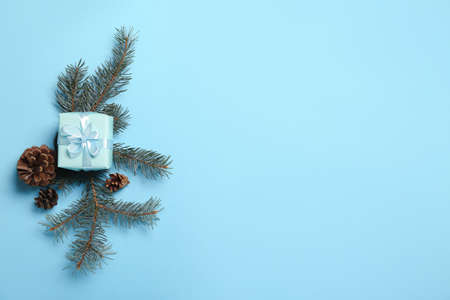 Christmas composition with gift box, pine cones and fir branches on blue backgroundの写真素材