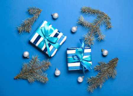 Christmas composition with gift boxes, balls and fir branches on blue backgroundの写真素材