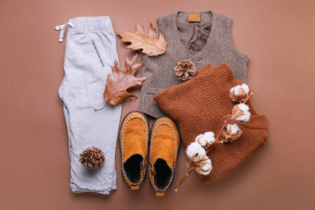 Stylish baby clothes, shoes and natural decor on color background
