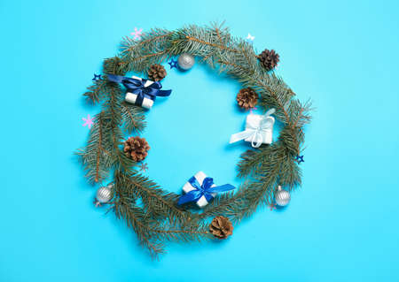 frame made of Christmas gift boxes, pine cones and fir branches on blue backgroundの写真素材