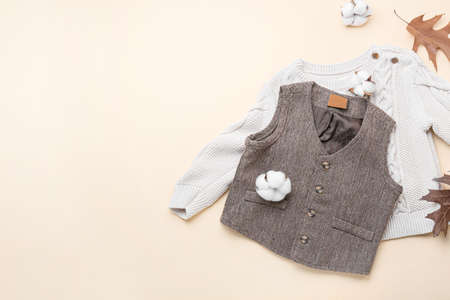 Stylish baby clothes and cotton flowers on color backgroundの写真素材
