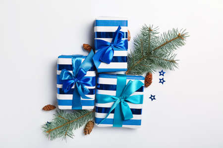 Christmas composition with gift boxes and fir branches on light background