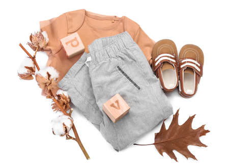 Baby clothes, shoes, toy and cotton branch on white backgroundの写真素材