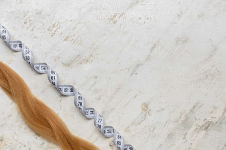 Red hair strand for donation with measuring tape on grunge backgroundの写真素材