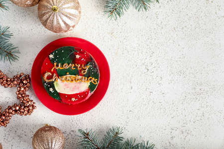 Plate with tasty bento cake and Christmas decor on white backgroundの写真素材