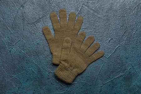 Pair of warm gloves on dark color background