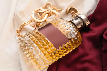 Perfume bottle and stylish jewelry on color fabric backgroundの写真素材