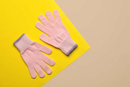 Pair of warm gloves on color backgroundの写真素材