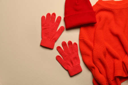 Warm gloves, hat and sweater on color backgroundの写真素材